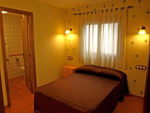 a small bedroom with a bed and a window at Can Joan in Rosell