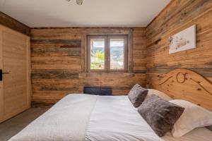 a bedroom with wooden walls and a large bed at La cabane du cerf in Les Allues