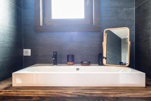 a white sink in a bathroom with a mirror at La cabane du cerf in Les Allues