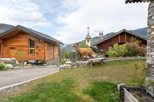 a goat standing on a bench in front of a house at La cabane du cerf in Les Allues