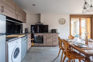 a kitchen with a table and a washer at La cabane du cerf in Les Allues +18 photos