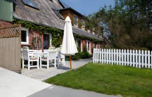 a white umbrella in the yard of a house at Ferienhof Rosenwarft in Pellworm