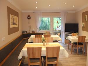 a dining room with tables and chairs and a television at Paradies Im Schwarzwald in Bad Peterstal-Griesbach