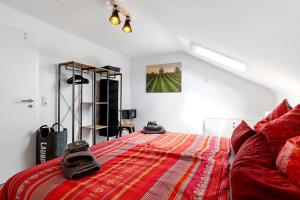 a bedroom with a red bed and a couch at Zum Hobelmann in Endingen