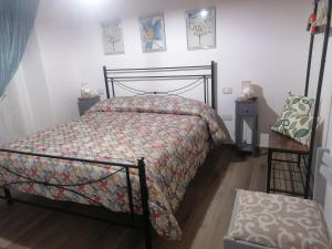 a bedroom with a bed with a floral bedspread at Casa vacanze Bau Mela in Villanova Strisaili