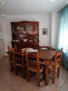 a dining room with a wooden table and chairs at Casa vacanze Bau Mela in Villanova Strisaili