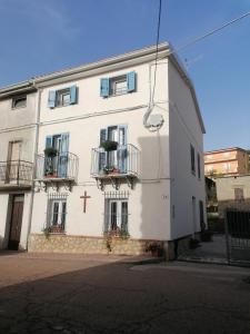 a white building with a cross on the side of it at Casa vacanze Bau Mela in Villanova Strisaili