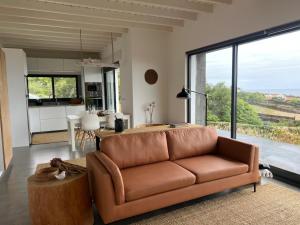 a living room with a brown couch and a kitchen at Casa da Arquinha in Santo Amaro +80 photos