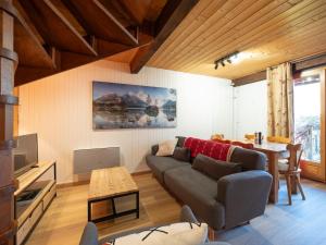 a living room with a couch and a table at Les Grands Champs Sud in Faverges
