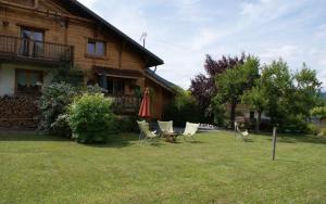 a yard with chairs and a table and a house at Les Grands Champs Sud in Faverges