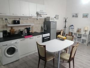 a kitchen with a table and a washing machine at Gradina Bulgarana in Bourg-Argental