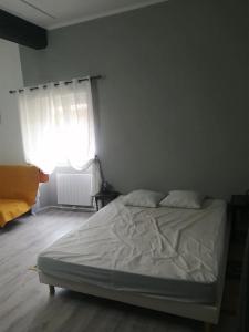 a white bed in a room with a window at Gradina Bulgarana in Bourg-Argental