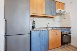 a kitchen with blue cabinets and a refrigerator at Casa Tanai in El Cotillo +14 photos