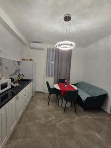 a small kitchen with a red table and chairs at Fabian Apart CenterTown in Tulcea