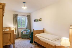 a bedroom with a bed and a chair and a window at Lina in Rottenbuch