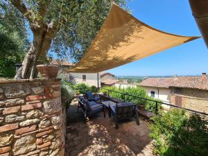 a patio with a table and chairs and a tree at La Terrazza, Cetona, Toscana in Cetona