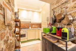 a kitchen with white cabinets and a stone wall at La Terrazza, Cetona, Toscana in Cetona +31 photos
