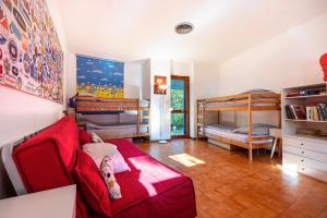 a living room with a red couch and bunk beds at Villa Franca San Zeno in San Zeno di Montagna