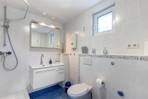 a white bathroom with a toilet and a sink at Ferienwohnung Norma in Taunusstein +16 photos