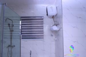 a bathroom with a shower and a phone on the wall at Winners Aparments in Mama