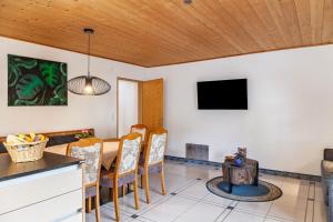 a dining room with a table and chairs and a tv at Hotel Sonnblick - Wohnung Klaus in Kartitsch
