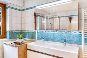 a bathroom with a sink and a mirror at Hotel Sonnblick - Wohnung Klaus in Kartitsch +18 photos