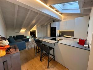a kitchen and living room with a couch and a table at La dolce vita - Lake Iseo in Paratico