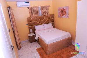 a small bedroom with a bed with a large headboard at Winners Aparments in Mama