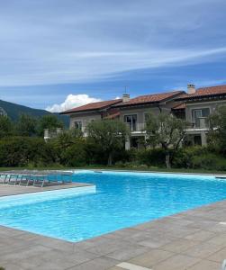 a large blue swimming pool in front of a house at La dolce vita - Lake Iseo in Paratico