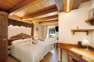 a bedroom with a large bed in a room with wooden ceilings at Appartamenti Cucu - 1 in Lillianes