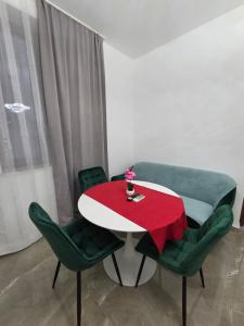 a table with green chairs and a red cloth on it at Fabian Apart CenterTown in Tulcea