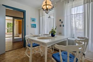 a dining room with a white table and chairs at Ferienhäuser Ella Walter - Efeuhaus in Nordstrand