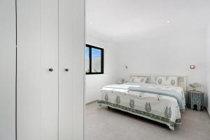 a white bedroom with a bed and a window at Alba House in Adeje +28 photos