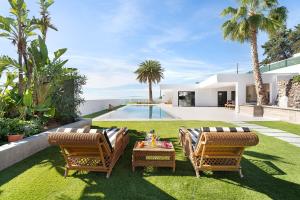 a backyard with two chairs and a table and a pool at Alba House in Adeje