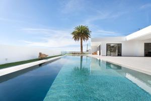 a swimming pool in front of a house at Alba House in Adeje