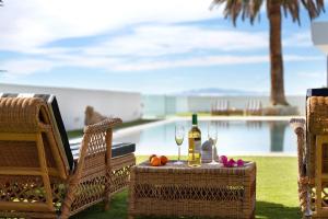 a table with a bottle of wine and two chairs at Alba House in Adeje