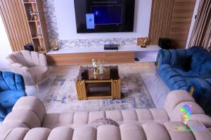 a living room with blue couches and a tv at Winners Aparments in Mama