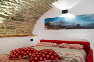 ein Schlafzimmer mit einem Bett und einer Ziegelwand in der Unterkunft La Cachette Relax in Aosta