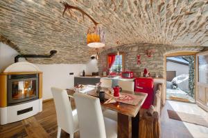 Eine Küche und ein Esszimmer mit Tisch und Kamin in der Unterkunft La Cachette Relax in Aosta