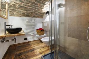 ein Badezimmer mit Waschbecken, Toilette und Dusche in der Unterkunft La Cachette Relax in Aosta + 20 Fotos