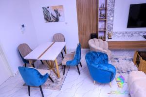 a dining room with blue chairs and a table at Winners Aparments in Mama