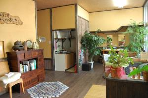 a living room filled with lots of potted plants at Sudomari Minshuku Friend in Yakushima