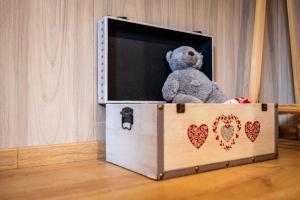 a teddy bear sitting in a box with a tv at Gîte Le Pieraline - Ventron in Ventron
