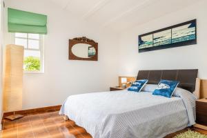 a bedroom with a bed with blue pillows on it at Casa Ullastre de Fornells in Fornells