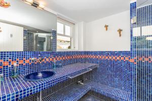 a blue tiled bathroom with a sink and a mirror at Casa Ullastre de Fornells in Fornells +18 photos