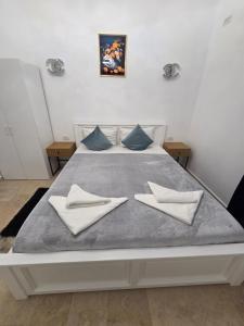 a large white bed with two pillows on it at Fabian Apart CenterTown in Tulcea