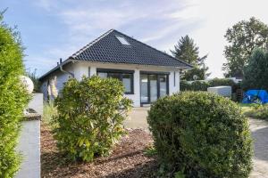 ein Haus mit zwei Büschen davor in der Unterkunft Uhse Loft in Heide