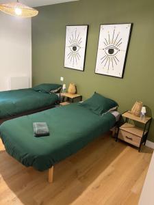 two beds in a room with green walls at L auberge des marais proche Marennes Oléron in Saint-Just