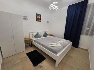 a small bedroom with a bed and a blue curtain at Fabian Apart CenterTown in Tulcea