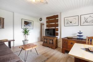 a living room with a couch and a tv at Ferienwohnung beim Roana in Inzell